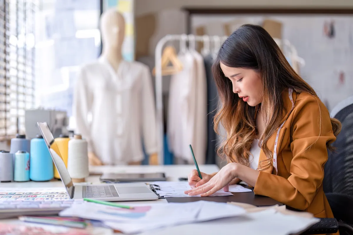 Modedesignerin skizziert an ihrem Arbeitsplatz